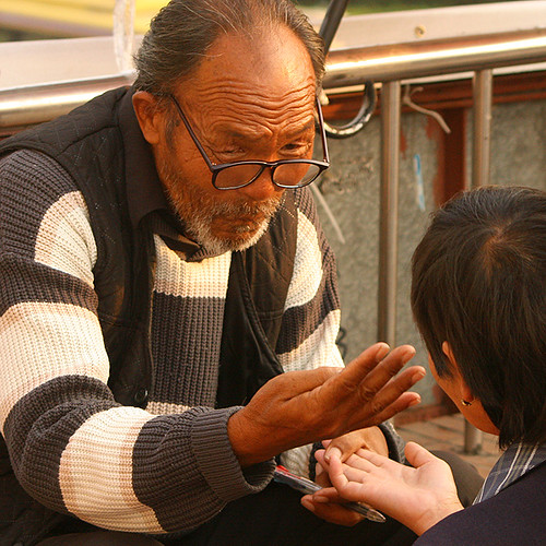 Palm reading in China: palm reader at work.