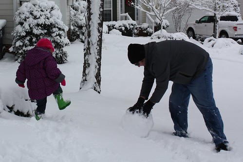 Dave starting a snowman, Catie stomping the snow