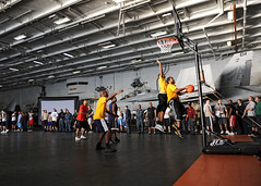 USS Abraham Lincoln Sailors hold basketball to...