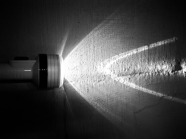 flash light or torch on painted block wall black and white