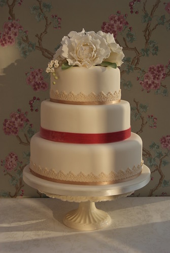 Three tier wedding cake with peonies and lily of the valley topper 