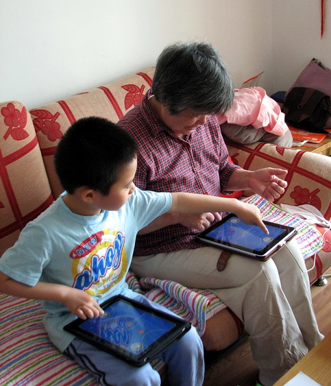 yoyo is playing multi-player ipad game with his grandma.