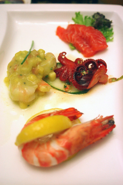 Starters of salmon sashimi, prawn and mango with avocado mousse, baby octopus, and poached tiger prawns
