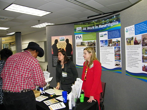Linda Cronin (Left), Public Affairs Specialist for FSA and Janice Stroud-Bickes (Right) Area Director for Rural Development are reviewing USDA program details with local producer at the USDA information booth