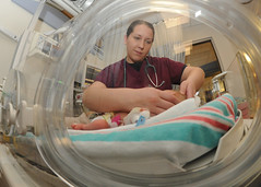 Navy medical officer examines baby during grad...