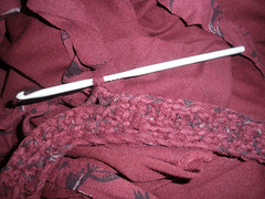 Cutting up old clothes to crochet a bag