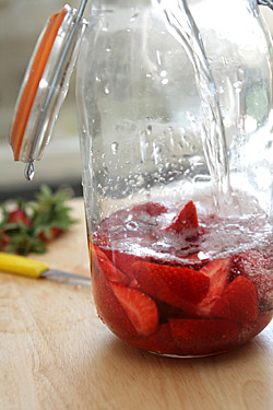 pouring vodka over strawberries