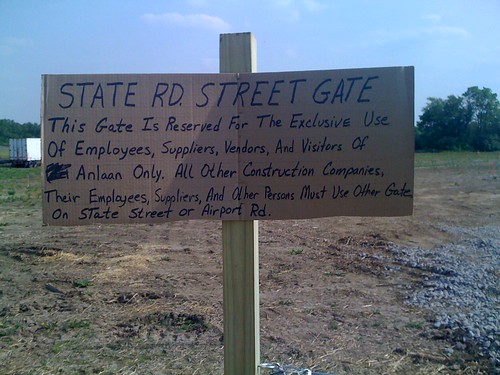 Crudely hand lettered sign at the gate of a construction site