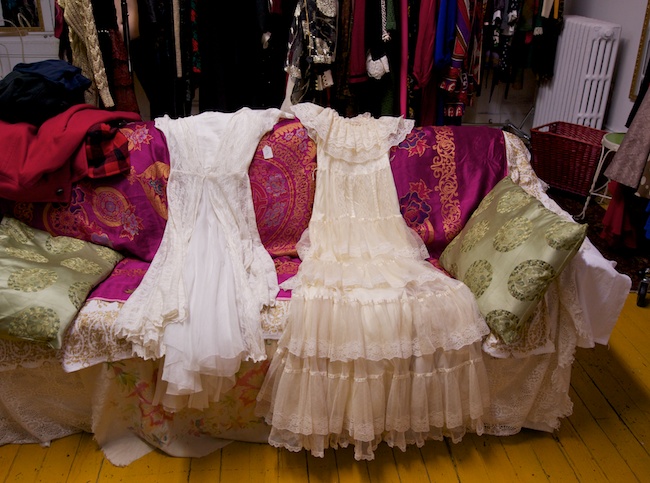 Vintage wedding dresses draped on the sofa by a customer