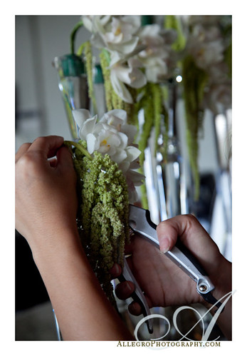 grace-ormonde-tabletop-mimosa-style- florish prepares green flowers to drape below white orchids for centerpiece and table arrangement for wedding style magazine- boston mass