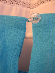 loop made from serger strand, which I re-enforced by sewing around it with knots; clear button