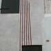 Bambino e tre foglie di ficus; 2003. Dipinto ai silicati e <br />
carboncini colorati su muro, cm 430x200.<br />
Maglione, Via Cossano.<br />
