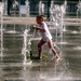 A young boy scooting through the water.