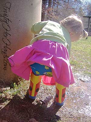 Baby girl playing in muddy water by the well