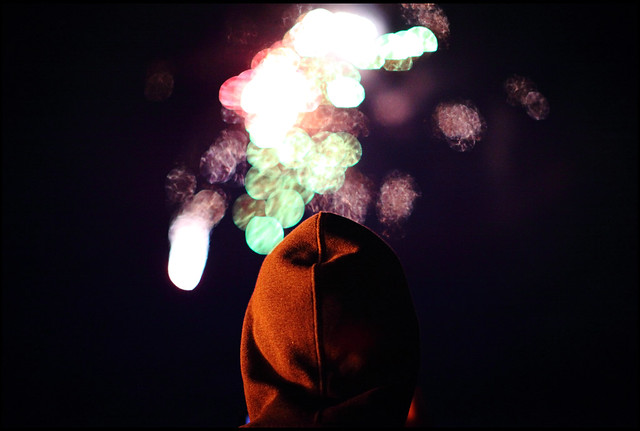 Hooded man watching fireworks