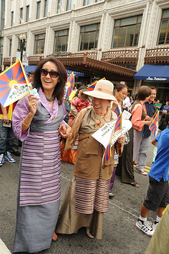 Delight! Two stylish Tibetan women, Tibetan people parade for World Peace with Tibetan Flags, near Verizon Center where Kalachakra is being given by His Holiness the 14th Dalai Lama, Washington D.C., USA by Wonderlane