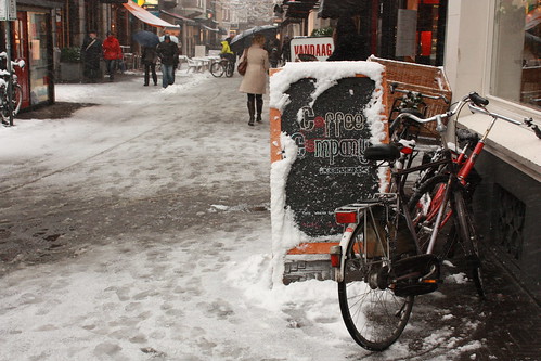 Bicicleta na neve em Haia em frente a um café