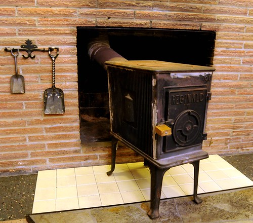 Reginald wood stove in brick fireplace with decorative hook and shovels, 2nd floor, Sand Point Way, Seattle, Washington, USA by Wonderlane