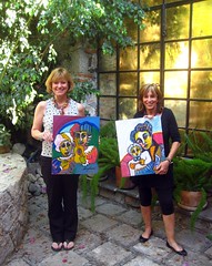 lynn and laurie with paintings they bought from a local artist
