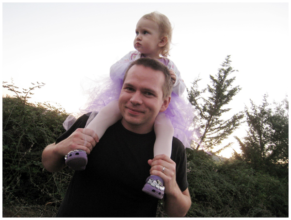 Daughter riding on Daddy's shoulders for her first Halloween