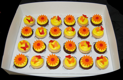 yellow orange and red cupcakes topped with butterflies and daisies box