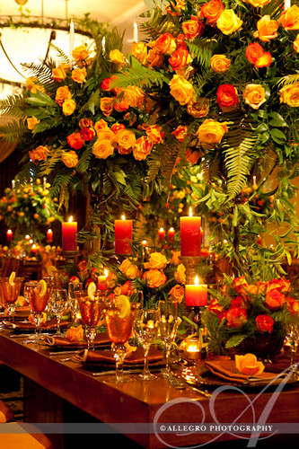 david-tutera-my-fair-wedding-ny-book-details- orange yellow amber candles and roses with wood tables- caribbean flare wedding reception