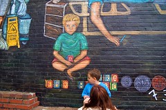 Regina Places her son next to his image in the mural 1