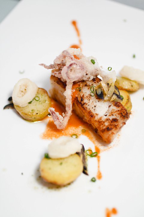 Pan Roasted Dory with mexican Romesco sauce served with Potatoes Fondant, Olives, Calamari and Nori Salt
