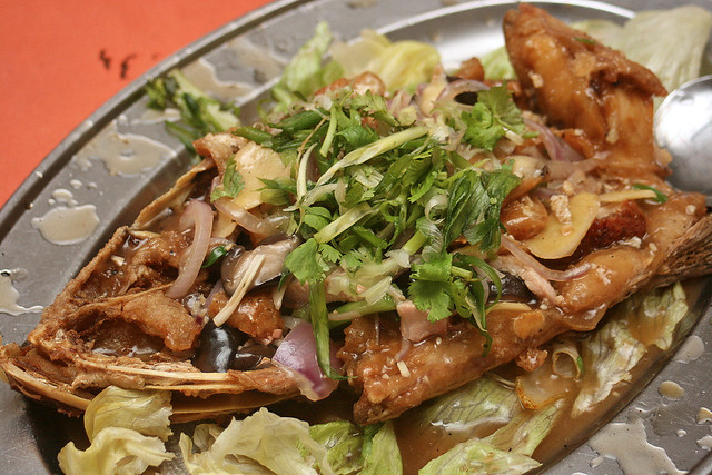 Fried fish head with lots of ginger, scallions, onions and mushrooms