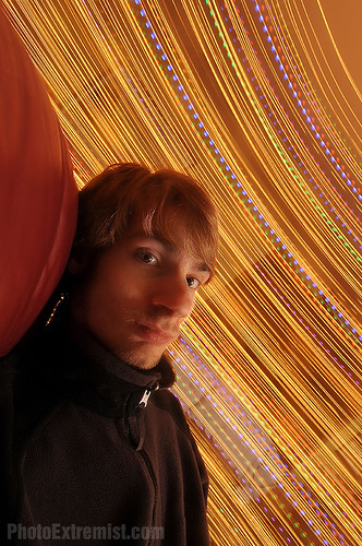 long exposure spinning in a chair next to christmas tree lights