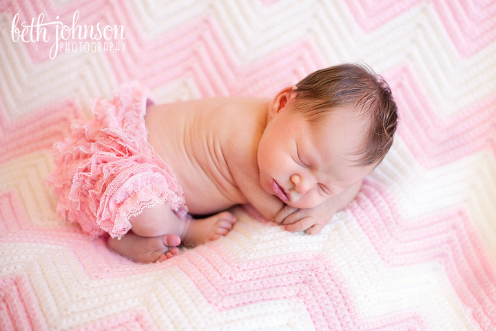 newborn baby on pink and white blanket