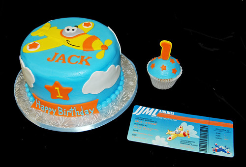Airplane themed first birthday cake in blue orange and yellow