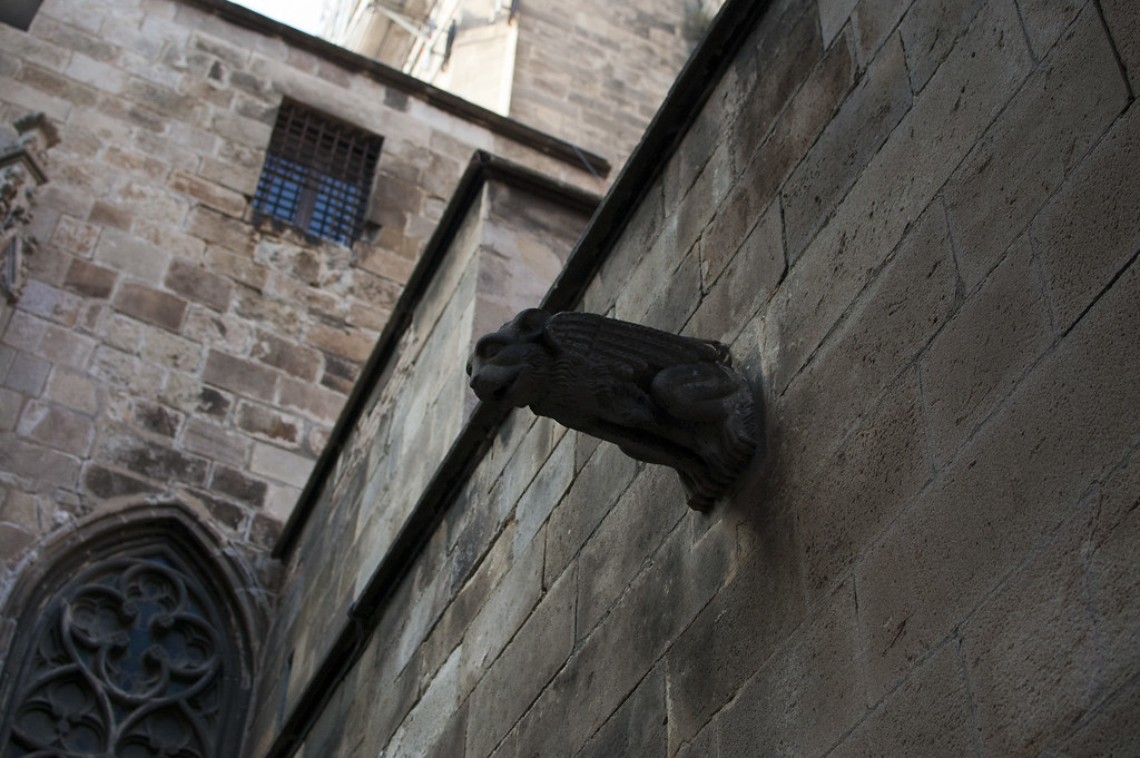 Photo of a gargoyle sticking out of a wall behind Barcelona's Cathedral