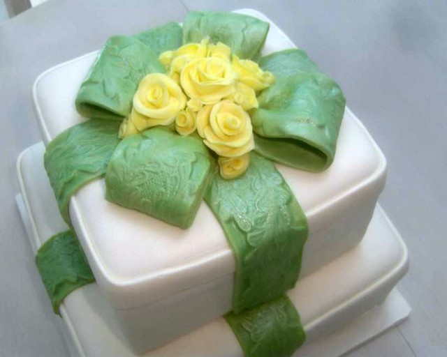 gift box cake with green embossed ribbon and yellow roses