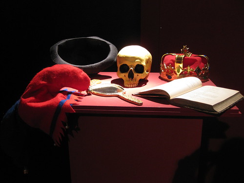 Photo aus dem Theatermuseum: Schädel, Krone, Spiegel, Buch auf einem Tisch