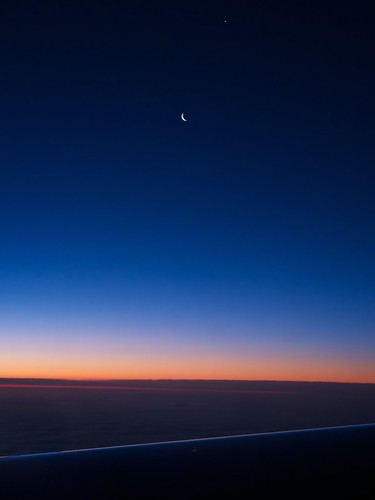 Sliver Waning crescent moon from my window seat on Virgin Atlantic this morning. The dot above the moon is either a blown pixel or the planet Venus.  (No, no, it