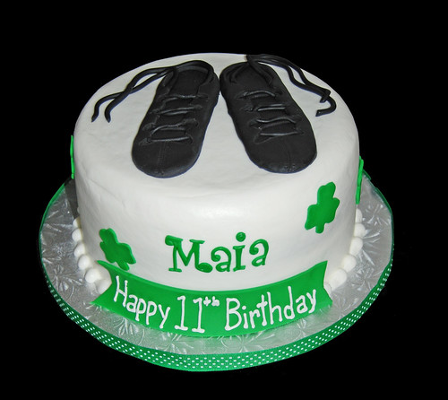 Green shamrock birthday cake topped with irish dancing shoes
