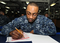 Sailor takes advancement exam aboard USS Peleliu.