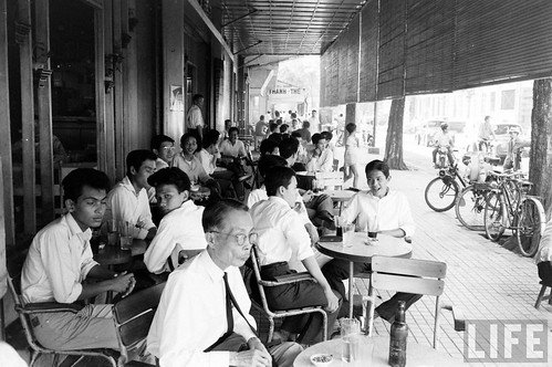 Men drinking at a sidewalk cafe in Saigon circa 1961