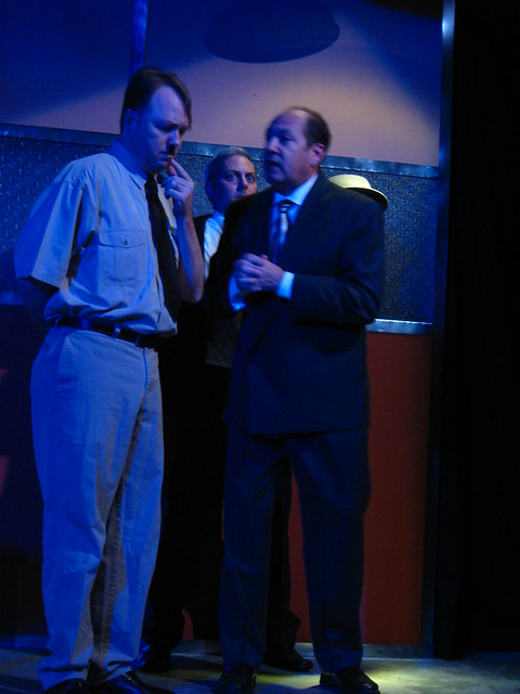 Hitler confers with a wealthy businessman (Bruno Oliver) while an American spy (Curt Bonnem) looks on.