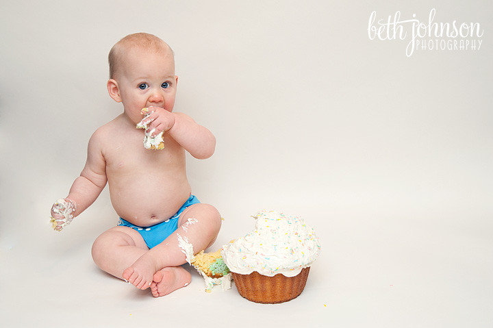 first birthday boy enjoying his cake