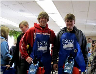 Huntsville Middle School 8th Graders, Colby Smith and Cody Levan, display the food safety gear given to them by FSIS employees.