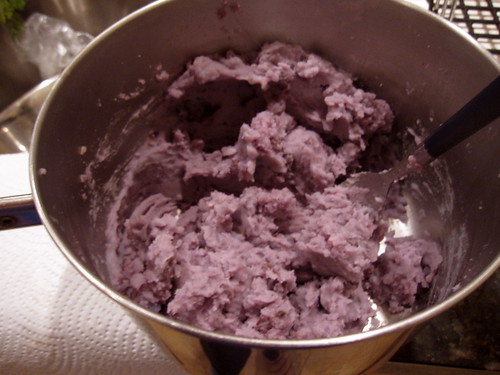 mashing the purple potatoes