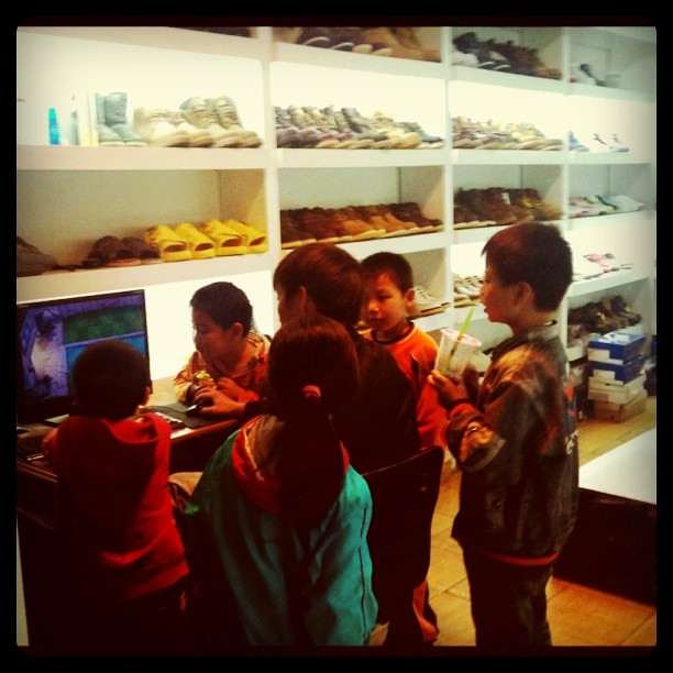 Fieldwork: neighborhood kids crowded around store owner playing games on computer