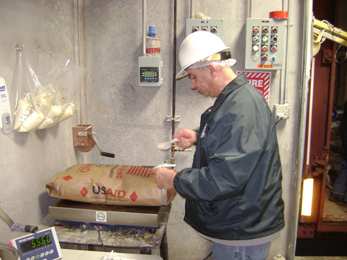 Don Folk of GIPSA’s Cedar Rapids Field Office weighs and collects a sample from an export food aid shipment.