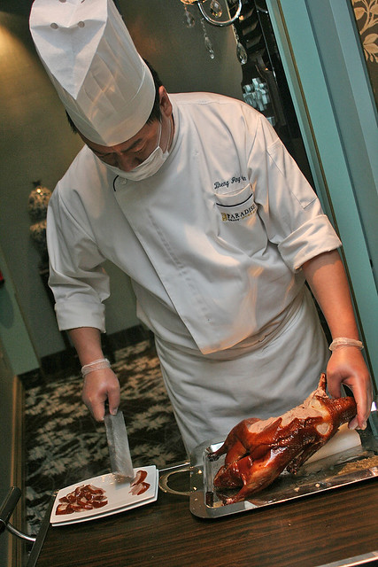 The chef carves up the duck while it is still hot