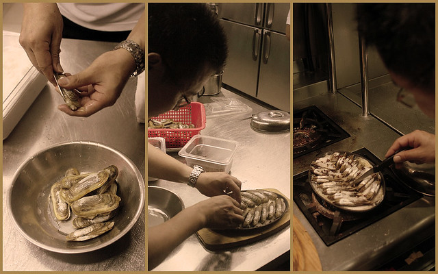 The chef cuts the clams, arranges them on a hotplate and cooks them there