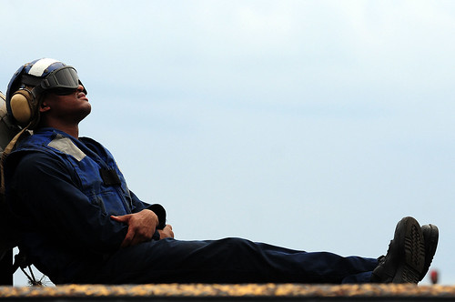Sailor takes a break before flight operations aboard USS Comstock.