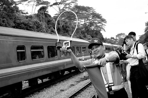 Mr Atan offering the token to incoming train