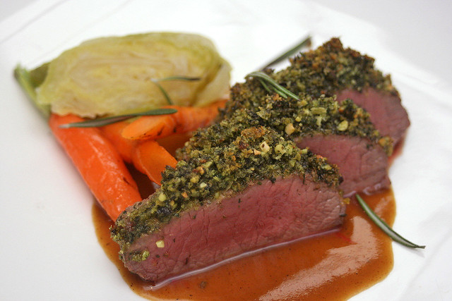 Lamb Loin - Roasted herb crusted lamb loin, baby carrots, braised savoy cabbage, Japanese curry jus, sumac powder
